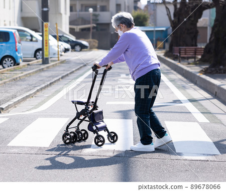 Elderly people taking a walk with a silver car Elderly people taking a walk with a silver car 89678066