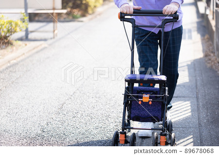 Elderly people taking a walk with a silver car 89678068