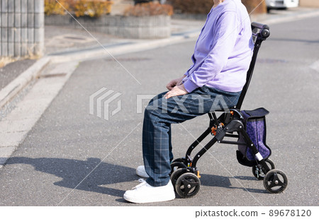 Elderly people taking a walk with a silver car 89678120
