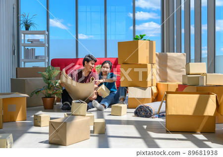 Young asian couple smiling, relaxing and resting on the floor after unpacking cardboard boxes in new house with cardboard boxes on floor Young asian couple smiling, relaxing and resting on the floor after unpacking cardboard boxes in new house with cardboard boxes on floor 89681938