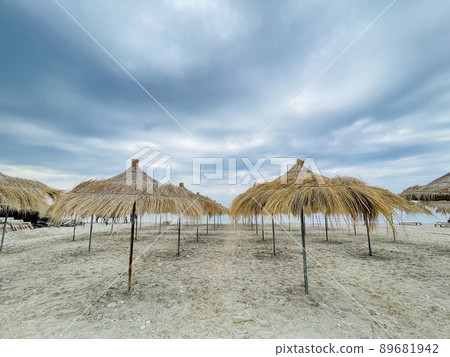 Straw beach umbrellas on a blue sky and sea background.Copy space Straw beach umbrellas on a blue sky and sea background.Copy space 89681942
