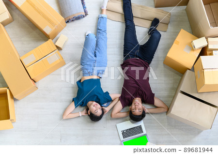 Top view of young asian couple working online shopping on laptop computer with cardboard parcel boxs of product for deliver at home. Start up online business concept. green screen computer Top view of young asian couple working online shopping on laptop computer with cardboard parcel boxs of product for deliver at home. Start up online business concept. green screen computer 89681944