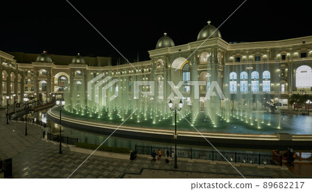 Place Vendome Mall  in Lusail city, Qatar interior view at night showing the architecture of the mall with big fountain in foreground 89682217