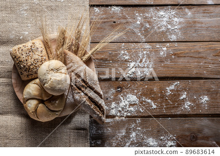 Bread with wheat ears and flour on wood board, top view. 89683614