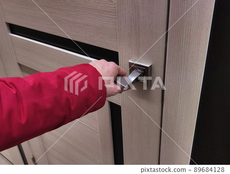 woman's hand holds door, handle opening it woman's hand holds door, handle opening it 89684128