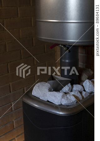 Crushed quartz stones lie on stove in steam room. Crushed quartz stones lie on stove in steam room. 89684131