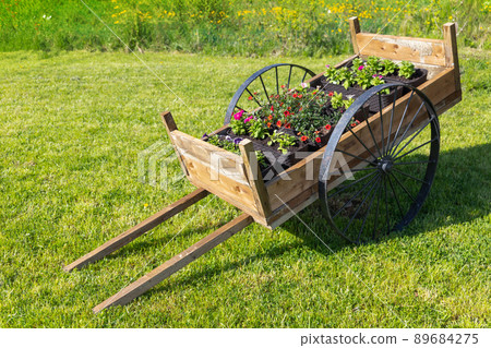 Vintage wooden cart with potted flowers Vintage wooden cart with potted flowers 89684275