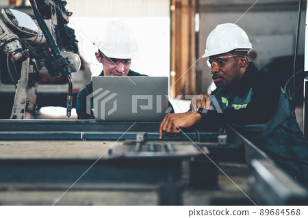 Factory workers working with adept robotic arm in a workshop 89684568