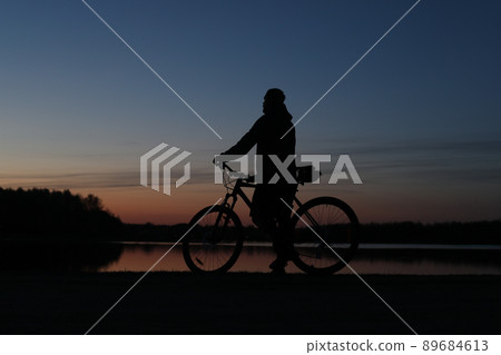 Silhouette of a bicyclist on the beach at sunset Silhouette of a bicyclist on the beach at sunset 89684613