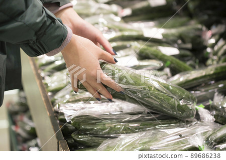 Young woman buying cucumber at the supermarket 89686238