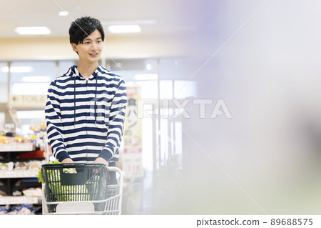 A young man shopping at a supermarket A young man shopping at a supermarket 89688575