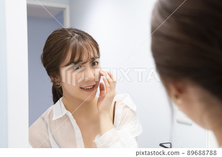 一個女人在鏡子裡檢查她的皮膚 89688788