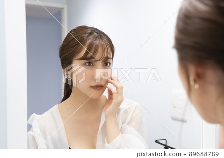 一個女人在鏡子裡檢查她的皮膚 一個女人在鏡子裡檢查她的皮膚 89688789