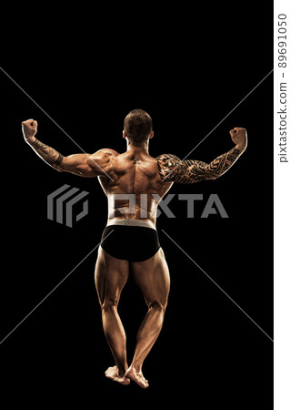 bodybuilder posing. Beautiful sporty guy male power. Fitness muscular body. Isolated on black background bodybuilder posing. Beautiful sporty guy male power. Fitness muscular body. Isolated on black background 89691050
