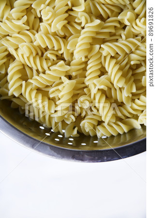 Boiled vermicelli noodles horns in a colander 89691826