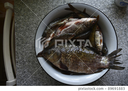 Fresh fish crucian carp and roach in a saucepan 89691883