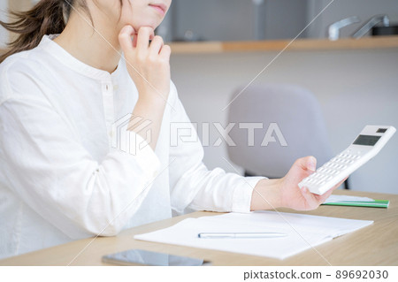 A woman holding a household account book A woman holding a household account book 89692030