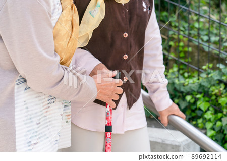 Senior woman descending stairs Senior woman descending stairs 89692114