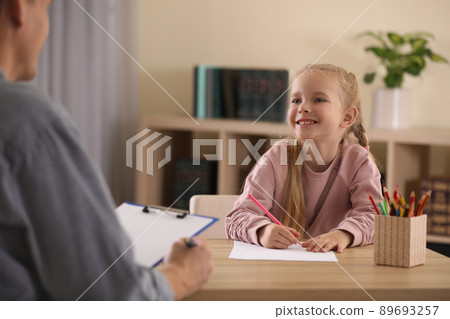 Little girl on appointment with child psychotherapist indoors 89693257