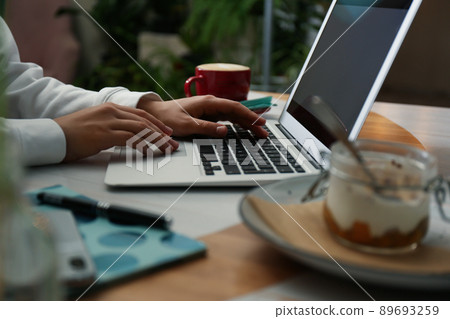 Blogger working with laptop in cafe, closeup Blogger working with laptop in cafe, closeup 89693259