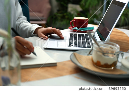 Blogger working with laptop in cafe, closeup Blogger working with laptop in cafe, closeup 89693260