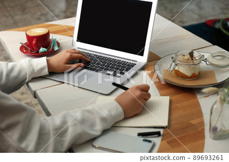 Blogger working with laptop in cafe, closeup Blogger working with laptop in cafe, closeup 89693261