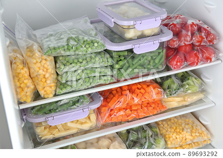 Plastic bags and containers with different frozen vegetables in refrigerator Plastic bags and containers with different frozen vegetables in refrigerator 89693292