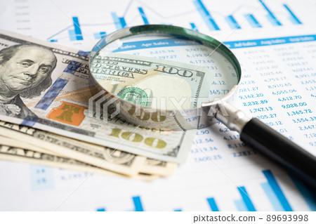 Magnifying glass with US dollar banknotes on charts graphs paper. Financial development, Banking Account, Statistics, Investment Analytic research data economy. 89693998