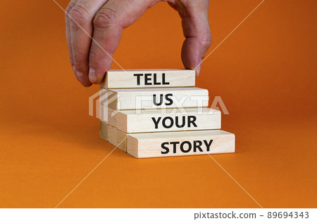 Tell us your story symbol. Wooden bloks with words 'Tell us your story'. Businessman hand. Beautiful orange background, copy space. Business, storytelling and tell us your story concept. Tell us your story symbol. Wooden bloks with words 'Tell us your story'. Businessman hand. Beautiful orange background, copy space. Business, storytelling and tell us your story concept. 89694343