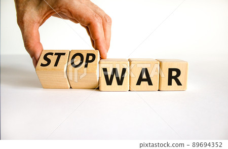 Stop war symbol. Businessman turns cubes and changes concept words War to Stop war. Beautiful white table white background. Business and stop war concept. Copy space. Stop war symbol. Businessman turns cubes and changes concept words War to Stop war. Beautiful white table white background. Business and stop war concept. Copy space. 89694352