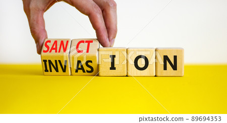 Sanction against invasion symbol. Businessman turns cubes and changes the concept word Invasion to Sanction. Beautiful white background. Business sanction against invasion concept. Copy space. 89694353