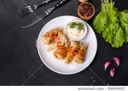 Cabbage rolls stuffed with ground beef and rice served on a white plate Cabbage rolls stuffed with ground beef and rice served on a white plate 89694802