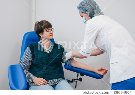 The patient takes a blood test at the clinic. The patient takes a blood test at the clinic. 89694904