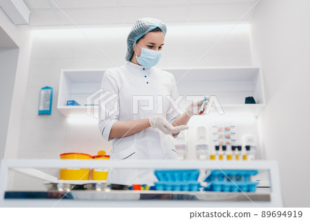 The doctor took a blood sample from the patient. Test tubes with blood in hands. 89694919