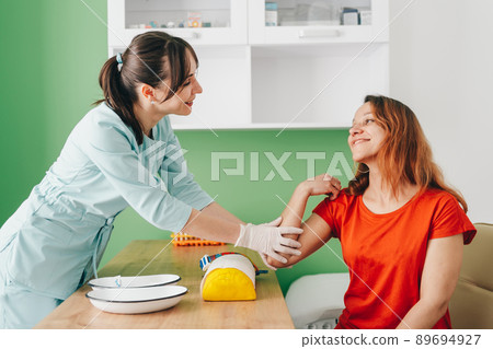 The doctor reassures the patient after blood collection. The doctor reassures the patient after blood collection. 89694927