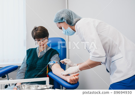The patient takes a blood test at the clinic. The patient takes a blood test at the clinic. 89694930