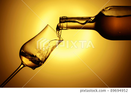 Digestive tulip of premium alcohol on a yellow background. Digestive tulip of premium alcohol on a yellow background. 89694952