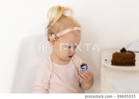 Funny baby with cochlear implant sitting at home and eating. Hear aid and medicine innovating technology concept 89695035