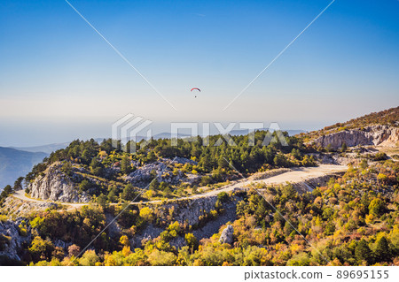 Paraglider flying in the sky, mountain view, Becici, Montenegro Paraglider flying in the sky, mountain view, Becici, Montenegro 89695155