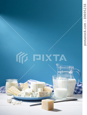 Dairy products on white wood base and blue background with  copy space. Vertical format. 89695238