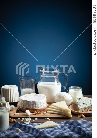 Dairy products on wood base and blue background with copy space. Vertical format. Dairy products on wood base and blue background with copy space. Vertical format. 89695239