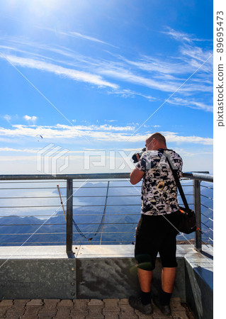 Travel photographer man with professional camera taking photos of on a top of Tahtali mountain near Kemer, Antalya Province in Turkey Travel photographer man with professional camera taking photos of on a top of Tahtali mountain near Kemer, Antalya Province in Turkey 89695473