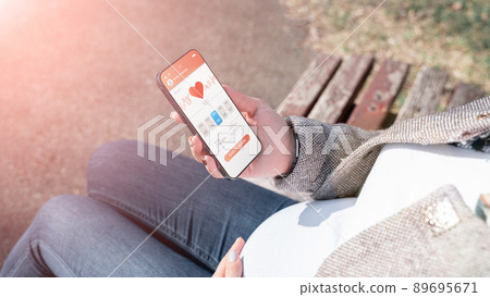Pregnancy smartphone app. Pregnant woman holding smartphone. Mobile pregnancy online maternity application. Concept maternity, pregnancy, childbirth. 89695671