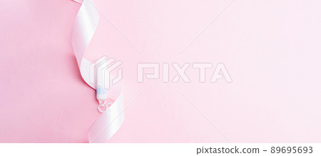 Tampon woman feminine hygiene. Pink ribbon with menstrual tampon on pink background. Menstruation feminine period. Soft tender protection for women critical days. 89695693