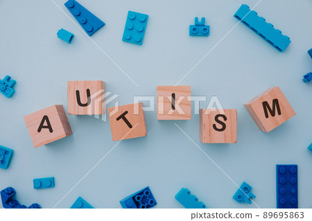 Puzzles and wooden blocks with AUTISM word. Close-up. World autism awareness day concept Puzzles and wooden blocks with AUTISM word. Close-up. World autism awareness day concept 89695863
