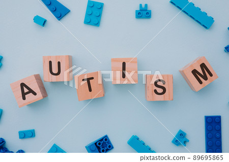 Blue puzzle and wooden blocks with AUTISM word. Close-up. World autism awareness day concept Blue puzzle and wooden blocks with AUTISM word. Close-up. World autism awareness day concept 89695865