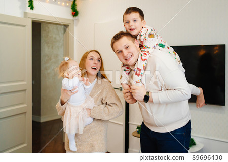 mom and dad with children play and fool around at home. happy family weekend. mom and dad with children play and fool around at home. happy family weekend. 89696430