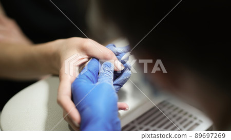 Closeup of hands of manicurist using electric cuticle remover for nail polish 89697269