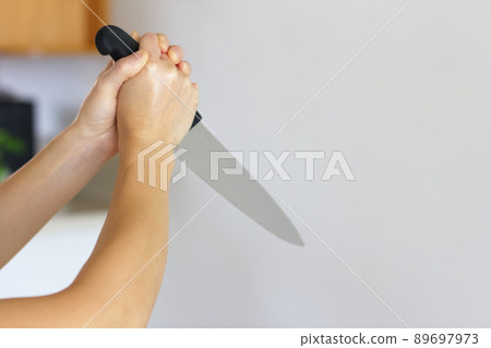 A woman's hand holding a kitchen knife A woman's hand holding a kitchen knife 89697973
