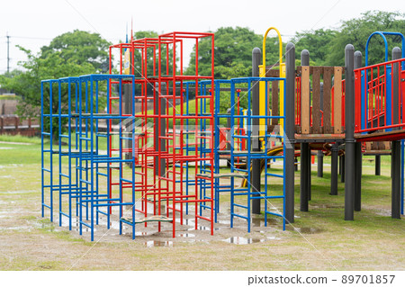 Outdoor playsets and benches wet in the rain 89701857